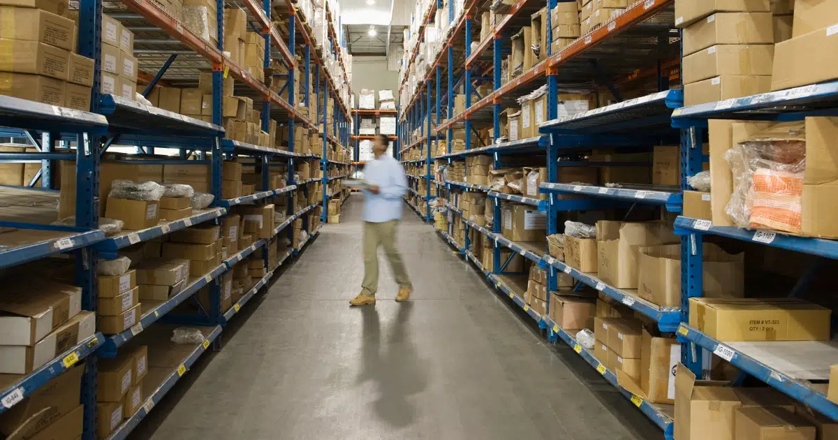 Retail business owner conducts inventory management in his warehouse with a scanner