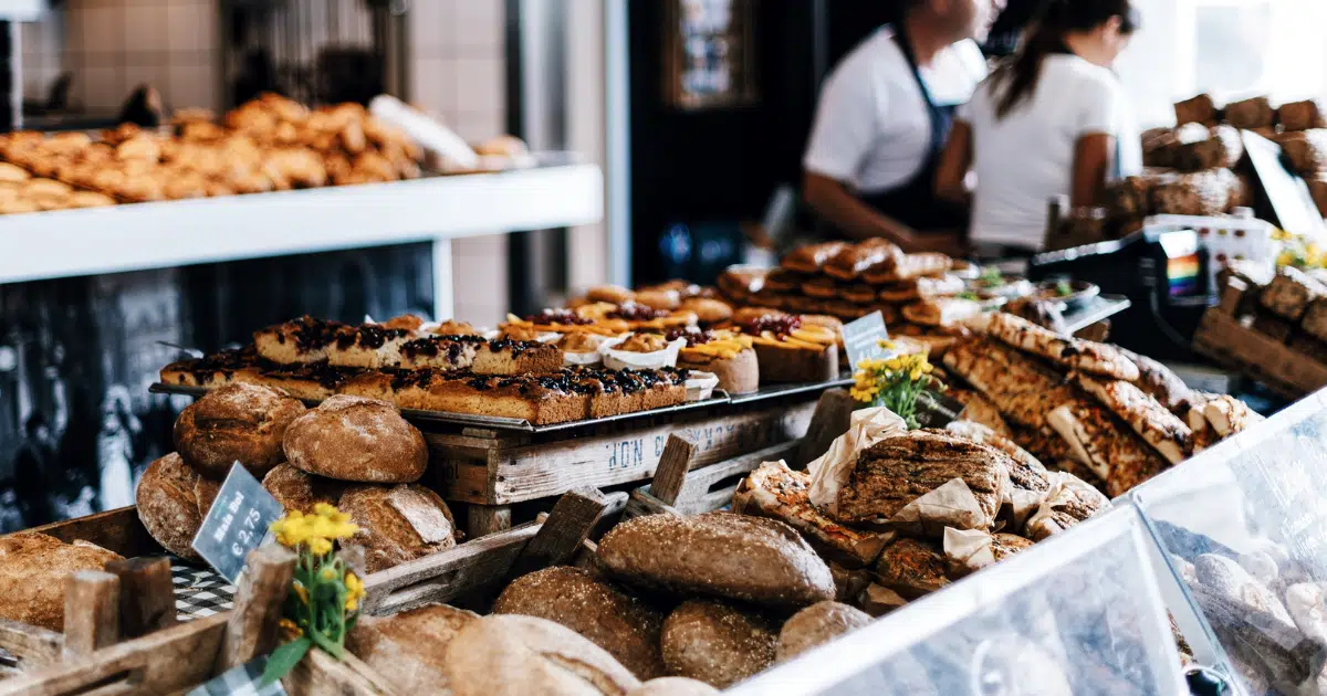 a photo showing a display of goods at a bakery with employees in the background