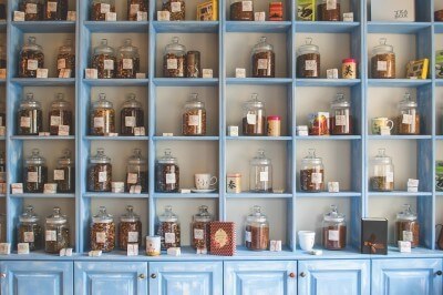a retail tea shop has their inventory neatly stocked on shelving
