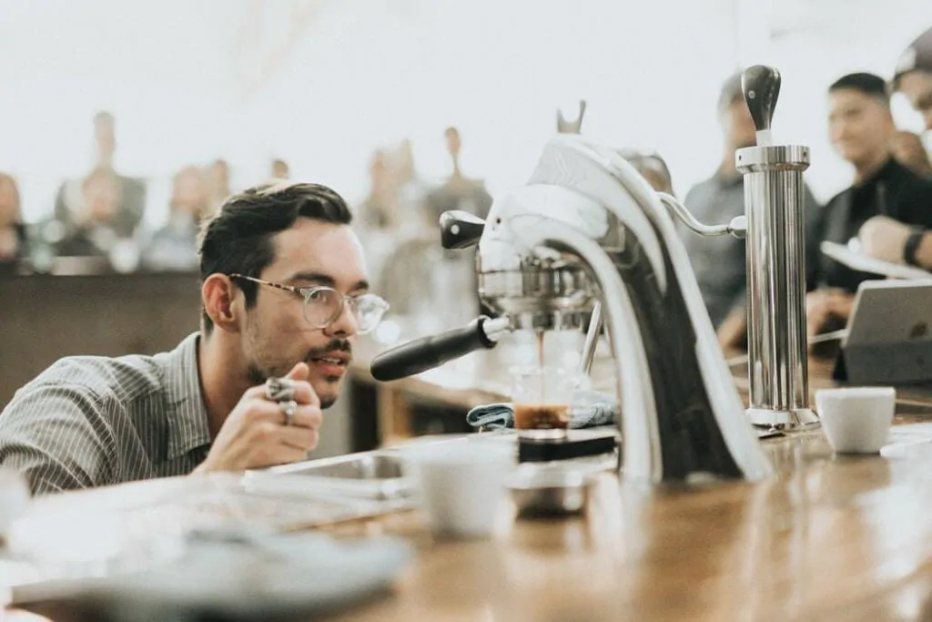 a barista uses coffee shop equipment to make an espresso