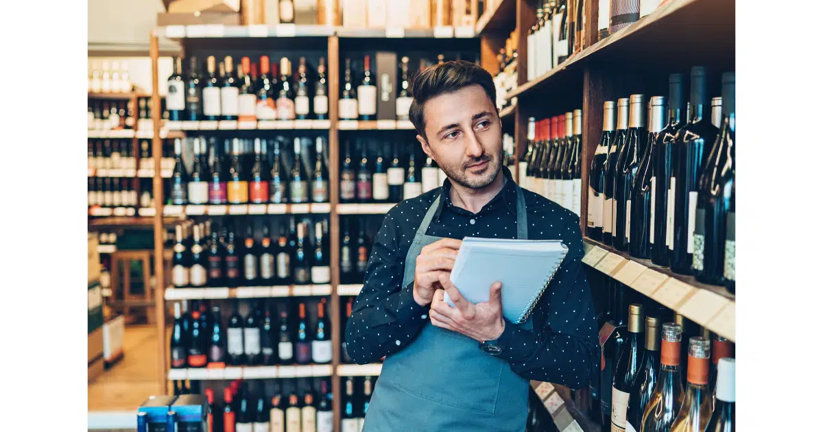 an employee counts retail inventory at a wine shop