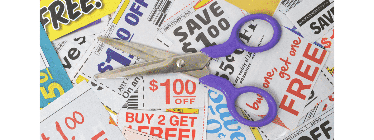 a scissors sits on top of coupons from retail businesses