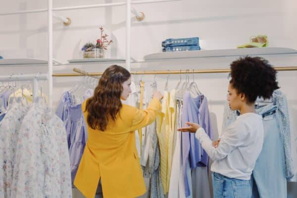 a salesperson helps a woman look for items in a retail store