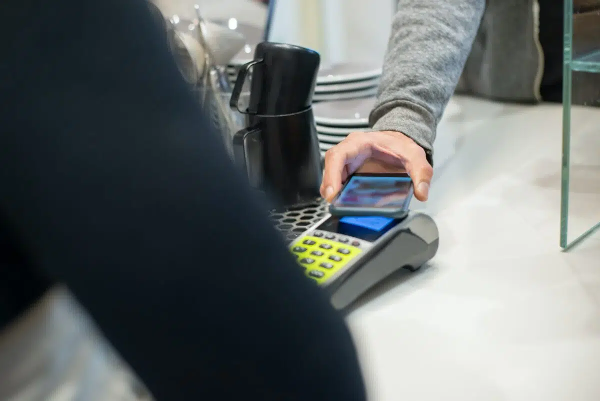 a shopper uses their smart phone to make a contactless payment