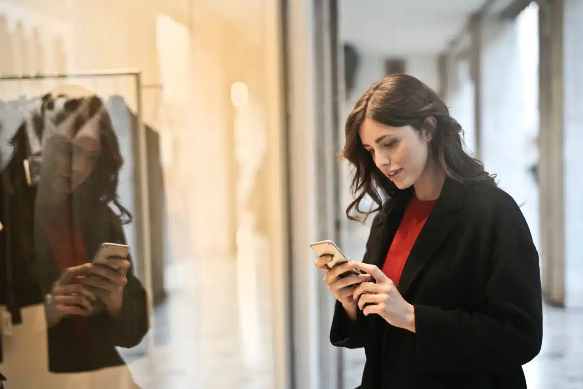 a window shopper looks on their phone 