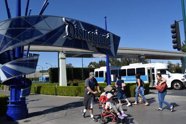 tourists walk to and from the Disneyland gate