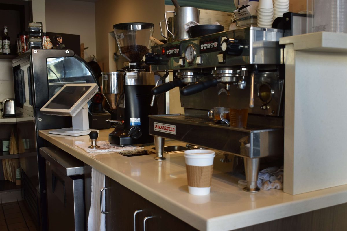 coffee shop equipment like grinders and an espresso machine sit on top of a a counter