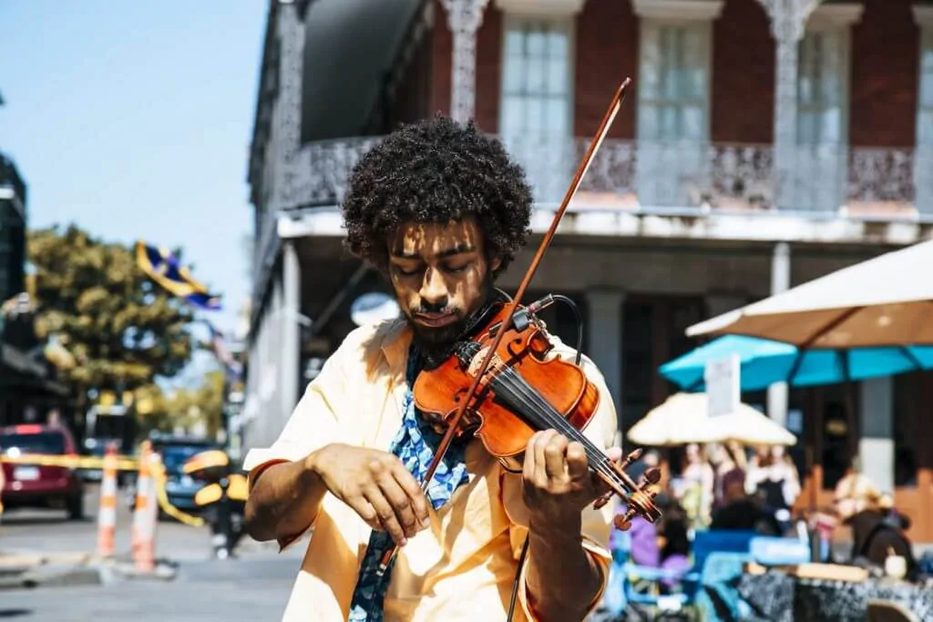 a musician plays a violin on the street