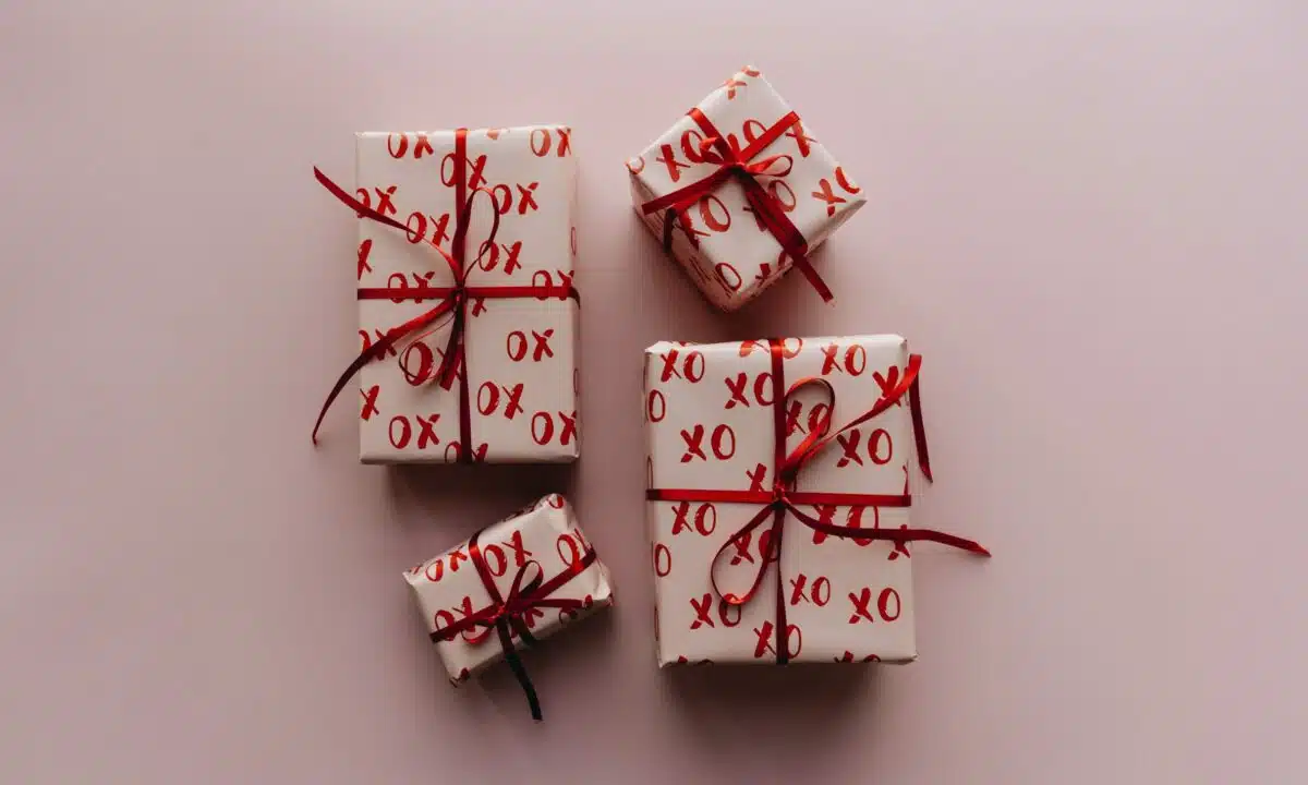 a valentines day sale promo with gift boxes wrapped in 'red xoxo' wrapping paper with red ribbons