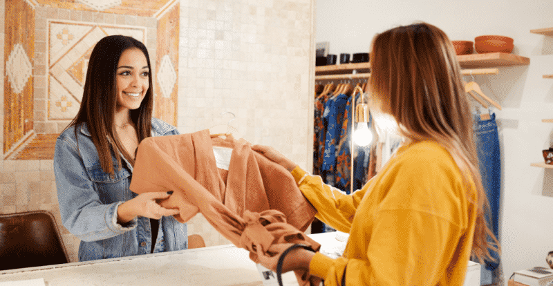 Person helping customer in clothing store