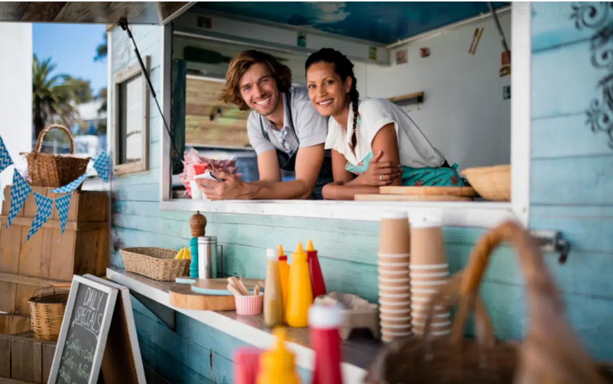 two food truck owners lean out of their window