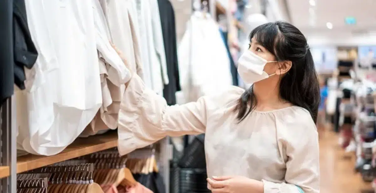 a shopper looks through clothes at a hybrid retail store