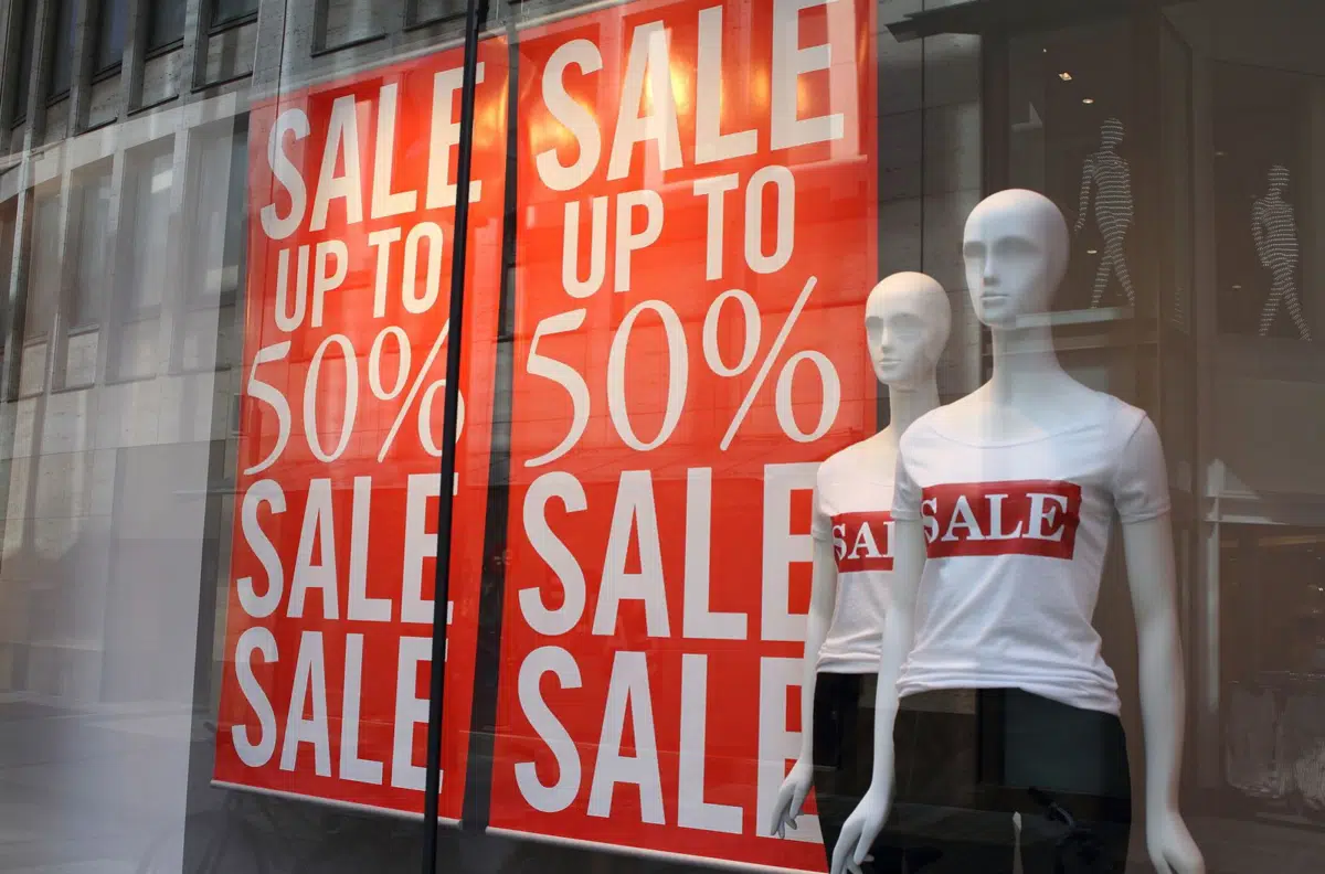 a retail clothing store window showing a 50% off sale