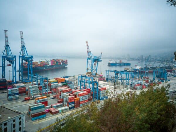 shipping containers sit at a port before being loaded onto a ship