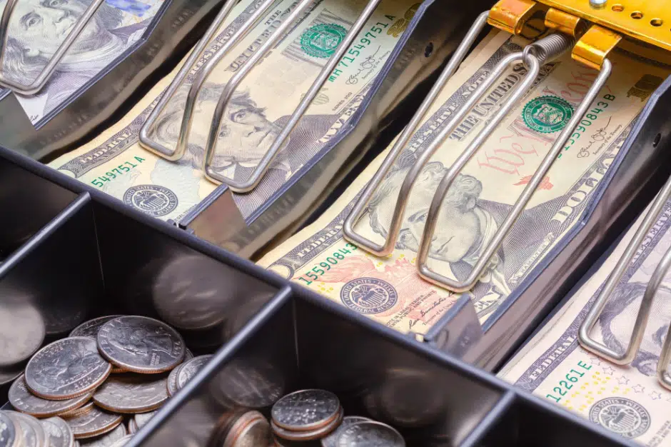 a retail cash register with bills and coins