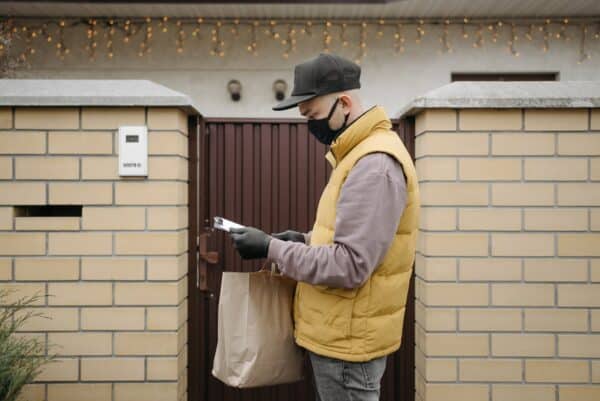 a delivery man brings cannabis from a dispensary to a customers home