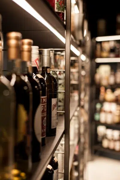 wine bottles sit on a shelf in a liquor store