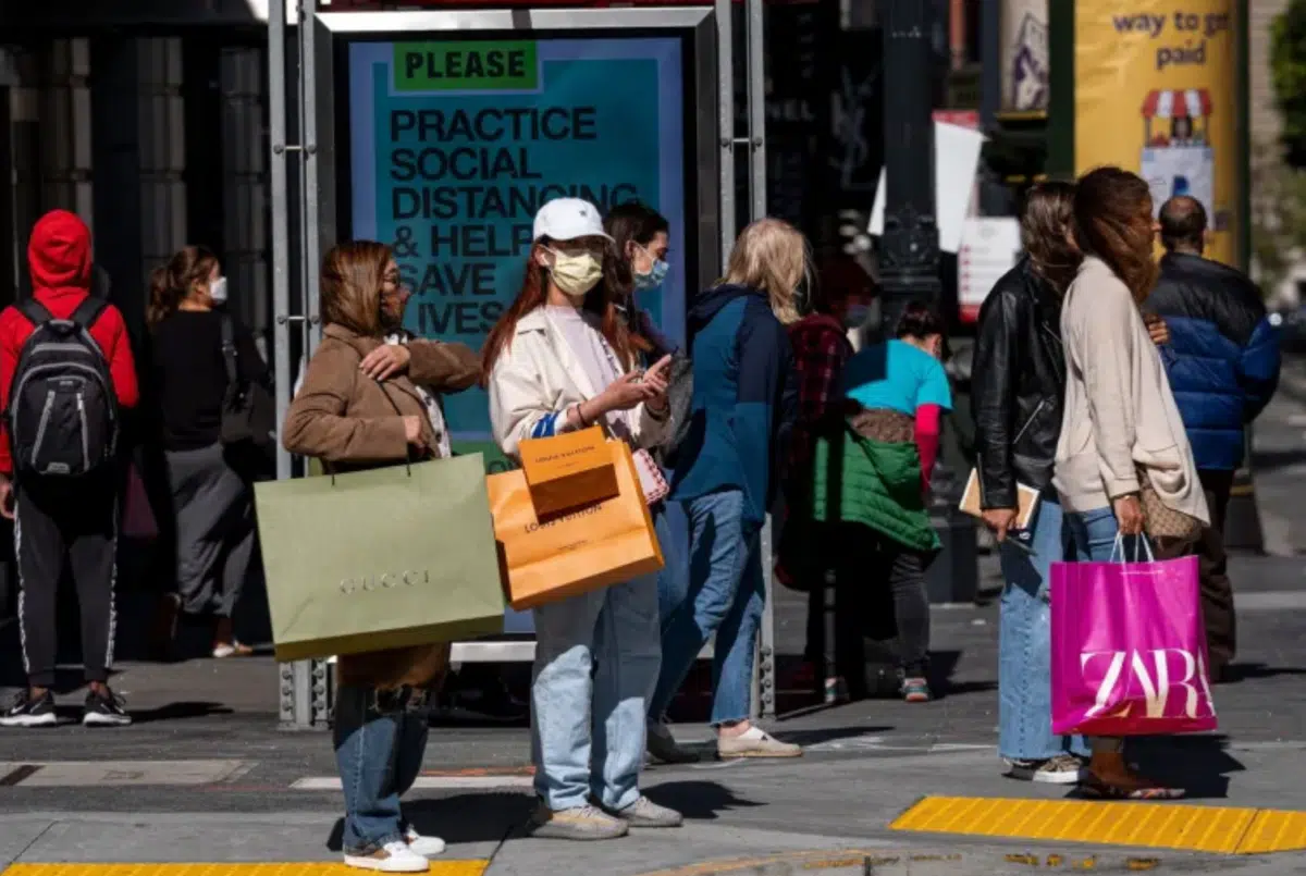 shoppers stand outside on the street