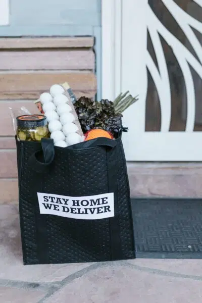 a bag with delivered convenience store groceries sits on a customers door step