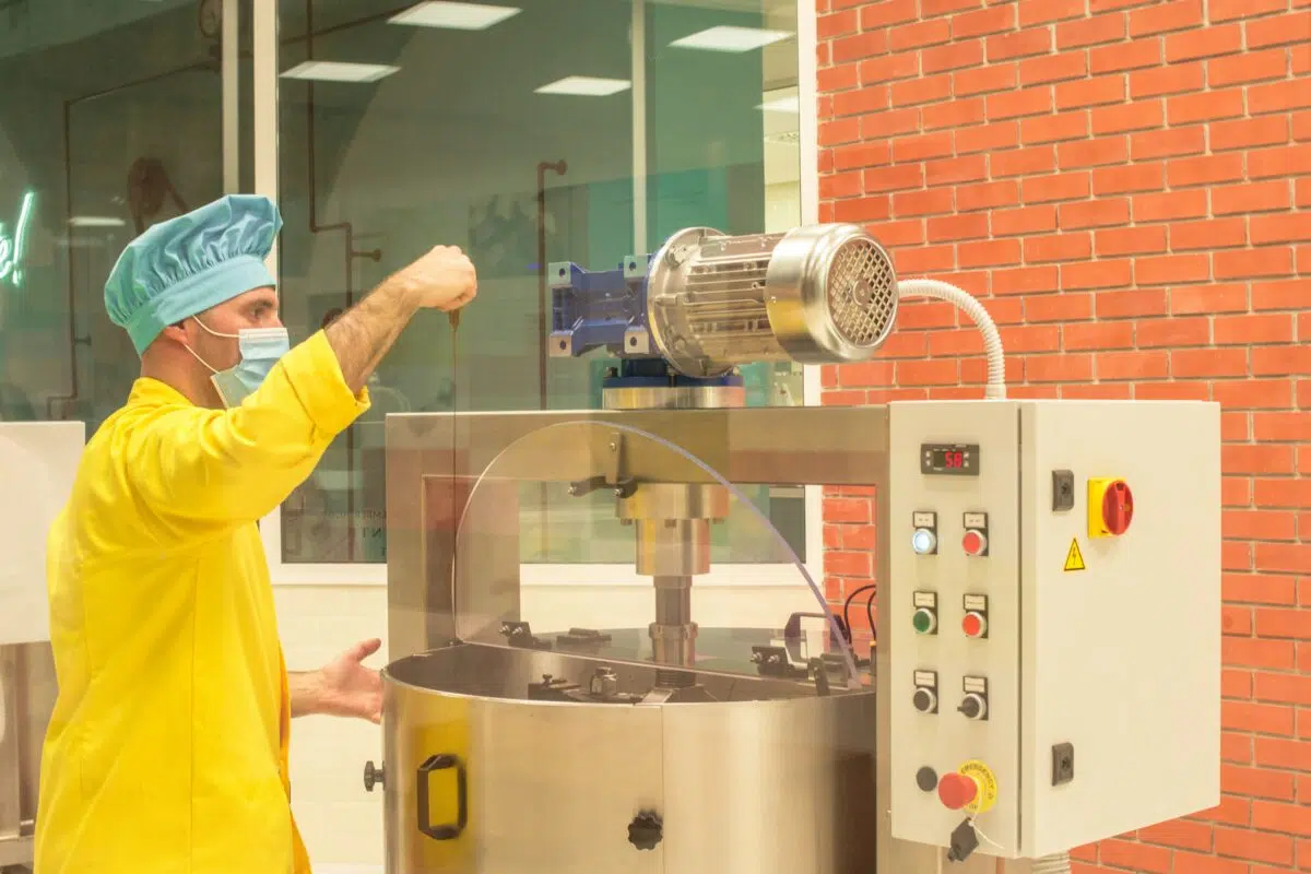 a cannabis edibles chef uses a machine to make marijuana chocolates