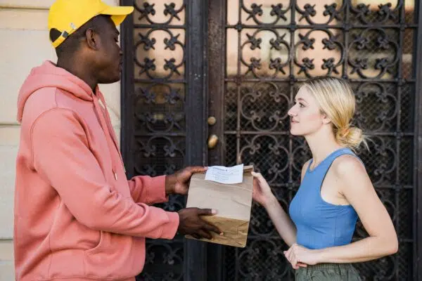 a cannabis delivery person hands off an order