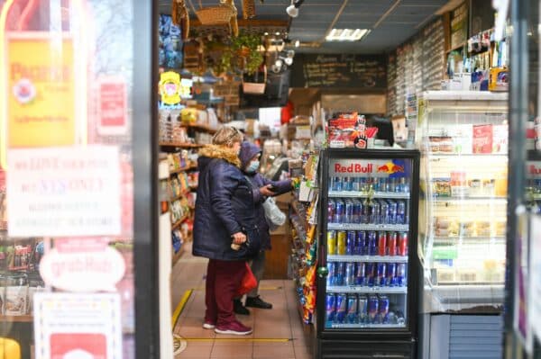 a photo showing the inside of a convenience store with two shoppers looking at items