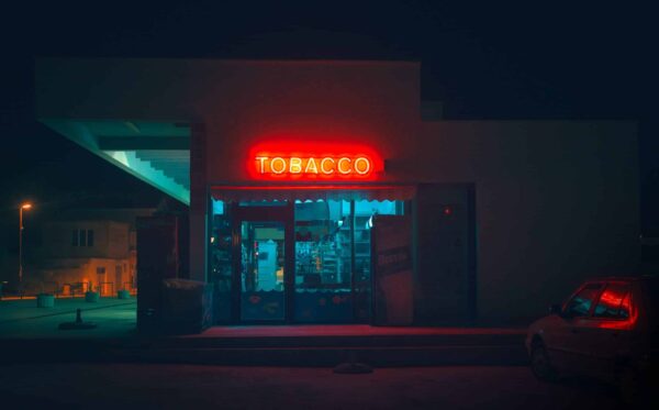 a photo showing a tobacco shop at night with a neon sign