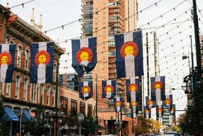a photo showing downtown denver with colorado flags hanging on strings