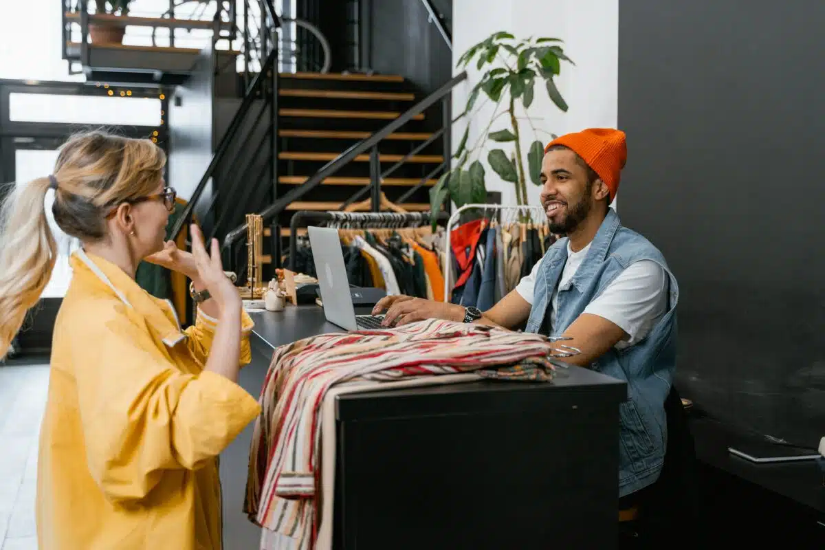 a customer and a salesperson chat in a clothing store