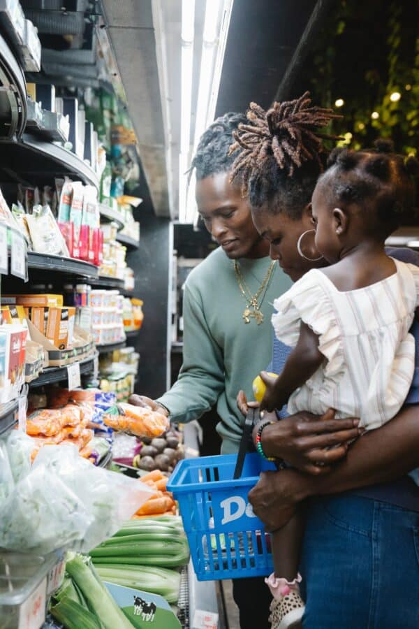 a family looks at prices of groceries at a convenience store