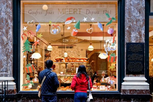 a photo of two people standing outside a bakery window display and looking at the visual merchandising techniques for christmas