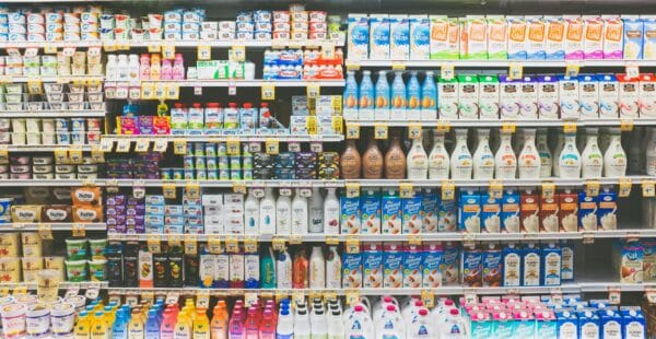 a photo of dairy products on refrigerated shelves in a grocery store