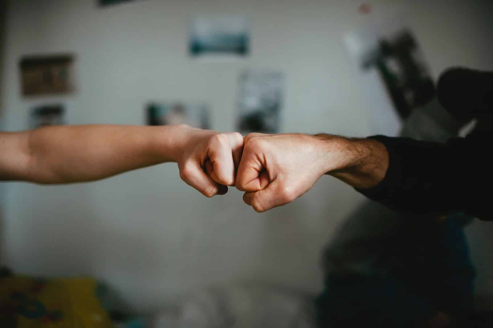 Two people fist bump to celebrate completing a project together at work