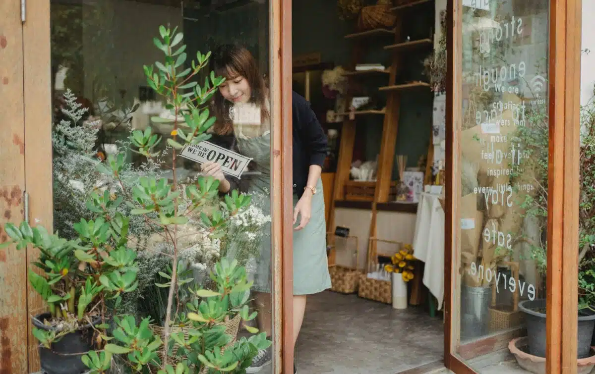 Shop owner changes the storefront sign to open