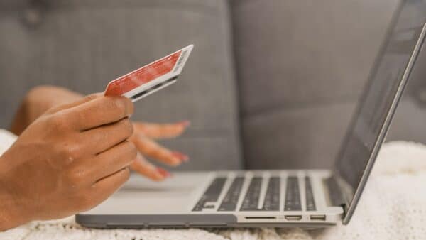 an ecommerce customer holds their credit card while making a purchase through an optimized online checkout process