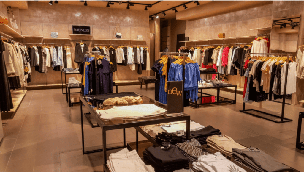 Picture showing clothes displayed in a clothing store.