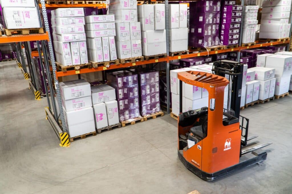 Man drives a forklift in a large retail warehouse space