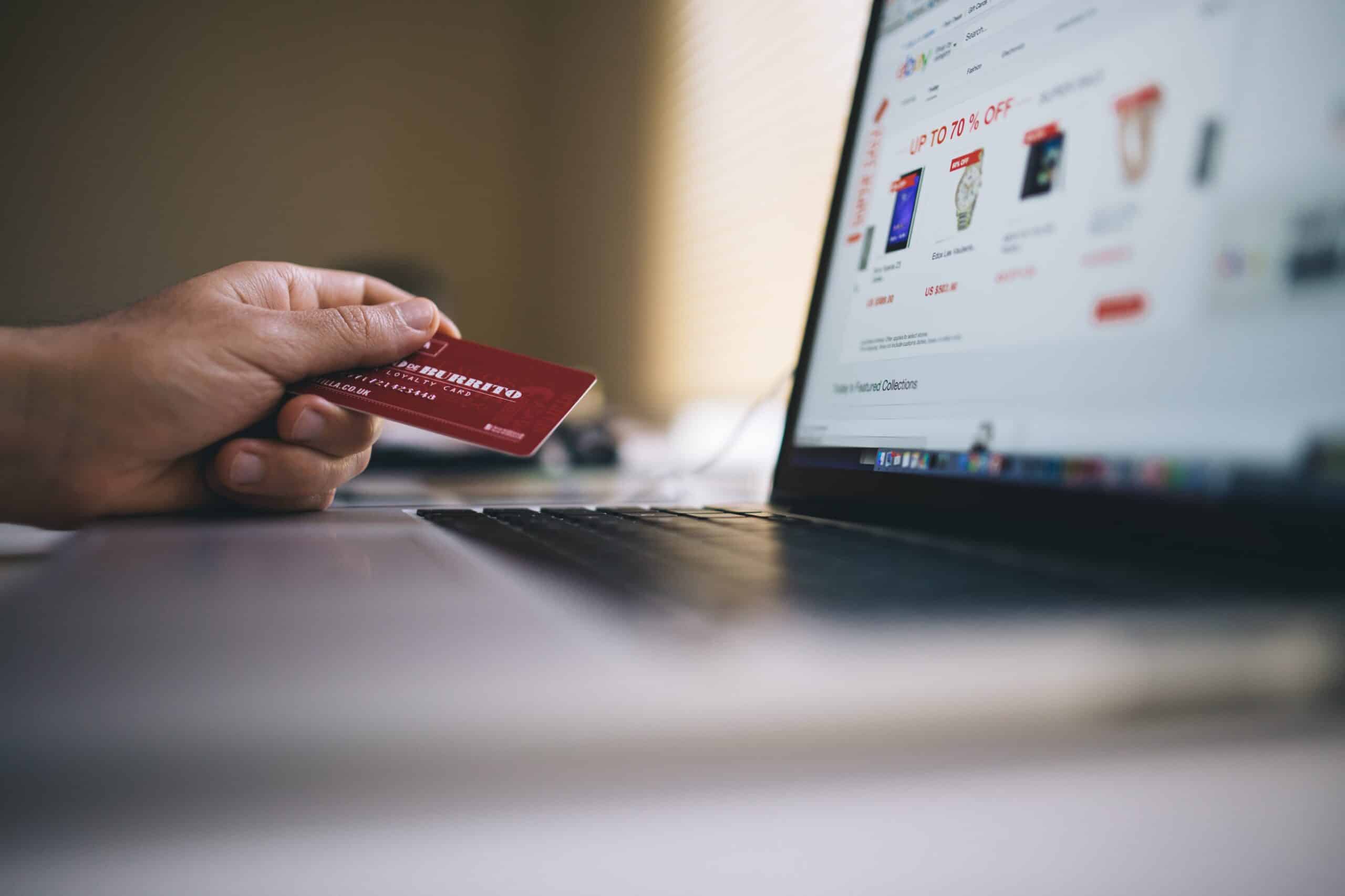 an eCommerce shopper uses a credit card to make a purchase on their laptop