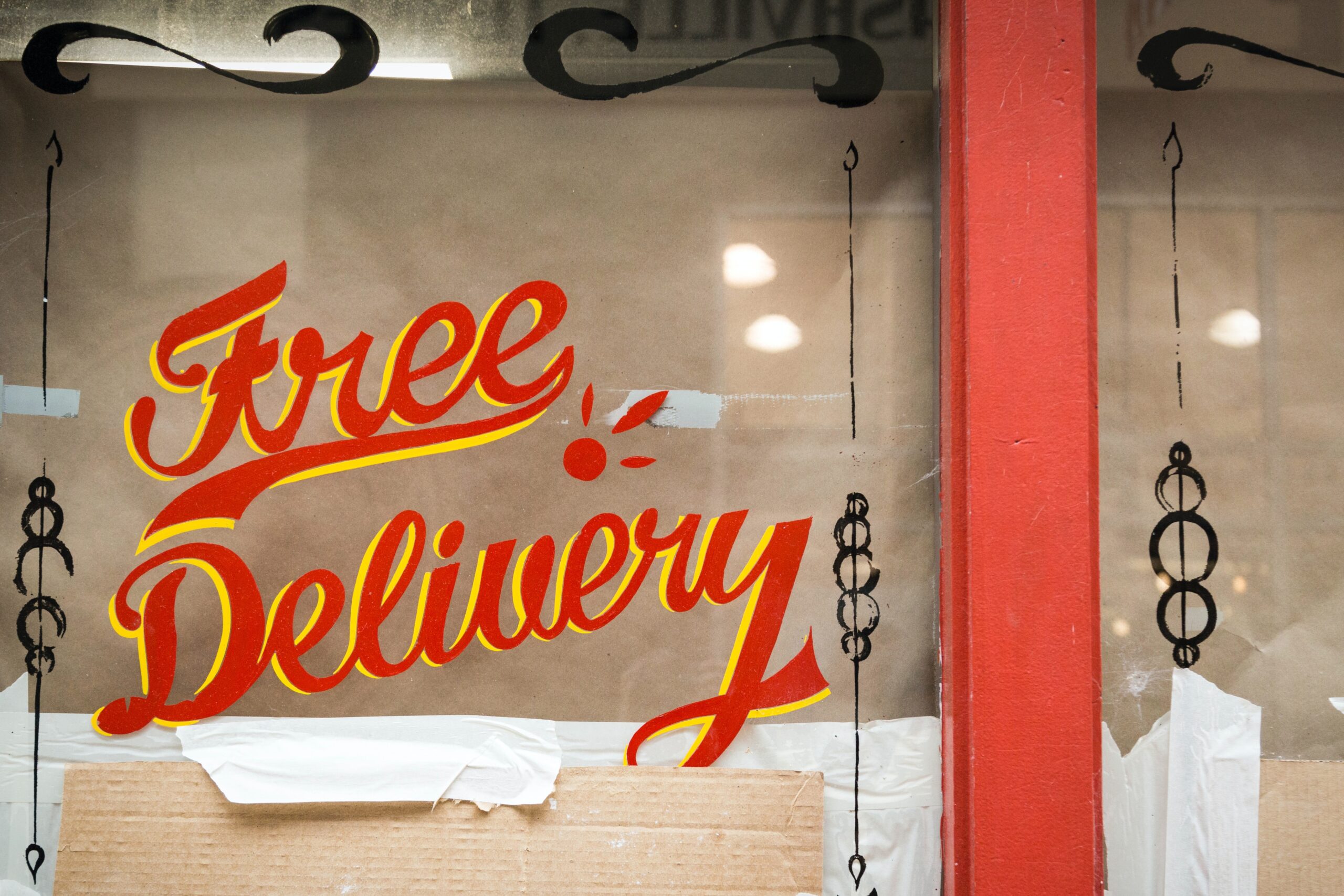 a sign on a brick and mortar shop reads 'free delivery'