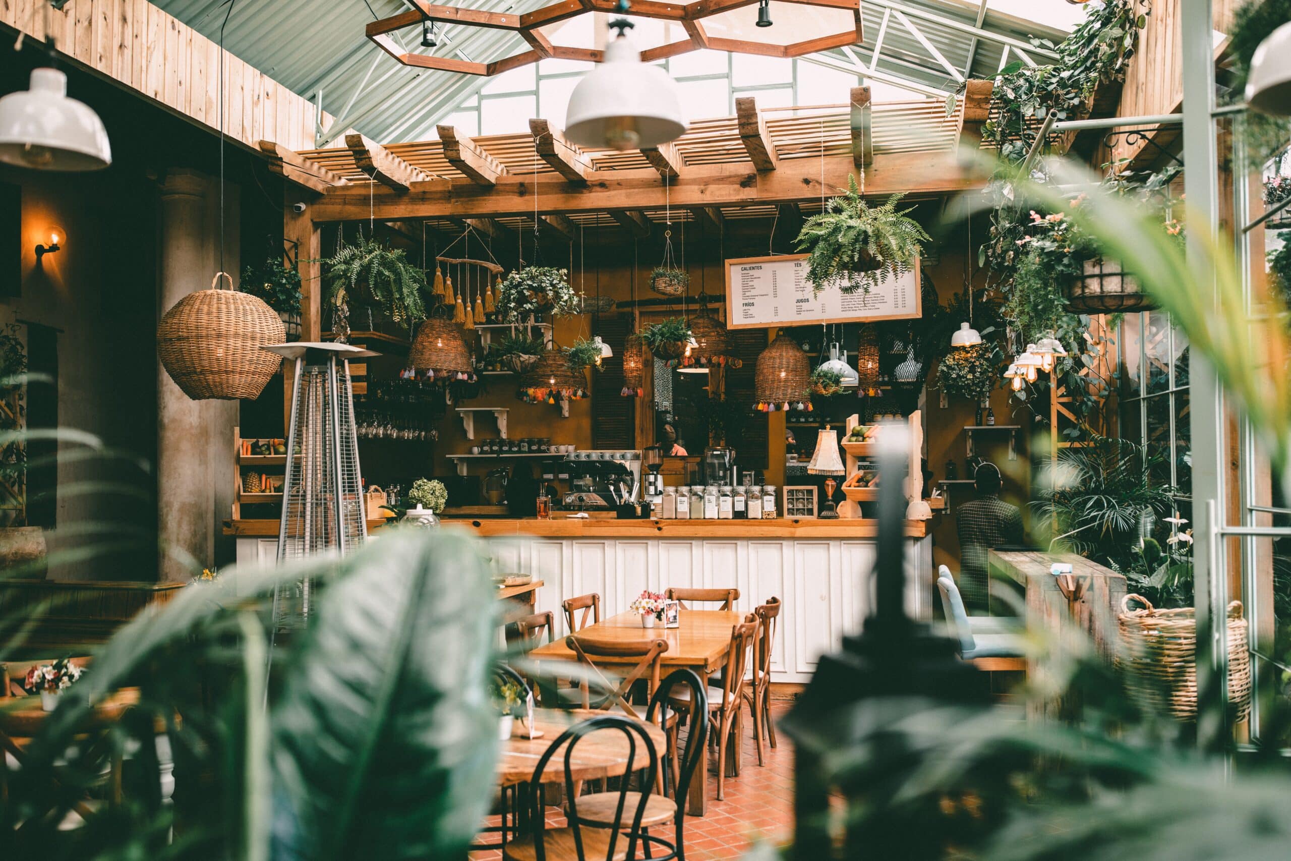 a coffee shop design with lots of plants and greenery