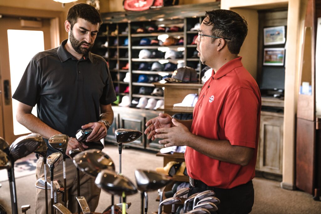 two retail employees at a golf store discuss assortment planning