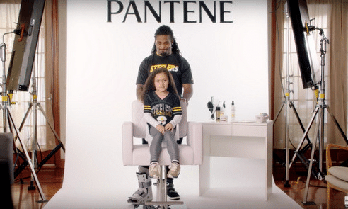 a still from a Pantene promotional video showing NFL player DeAngelo Williams doing his daughters hair