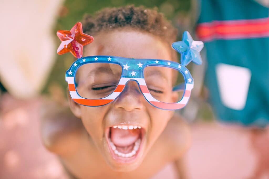 a picture of a kid celebrating labor day wearing stars and stripes glasses