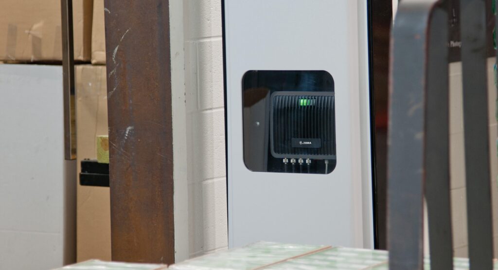 a fixed RFID reader sits in a wall in a warehouse