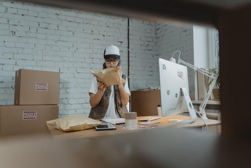 a retail employee looks over inventory while talking on the phone