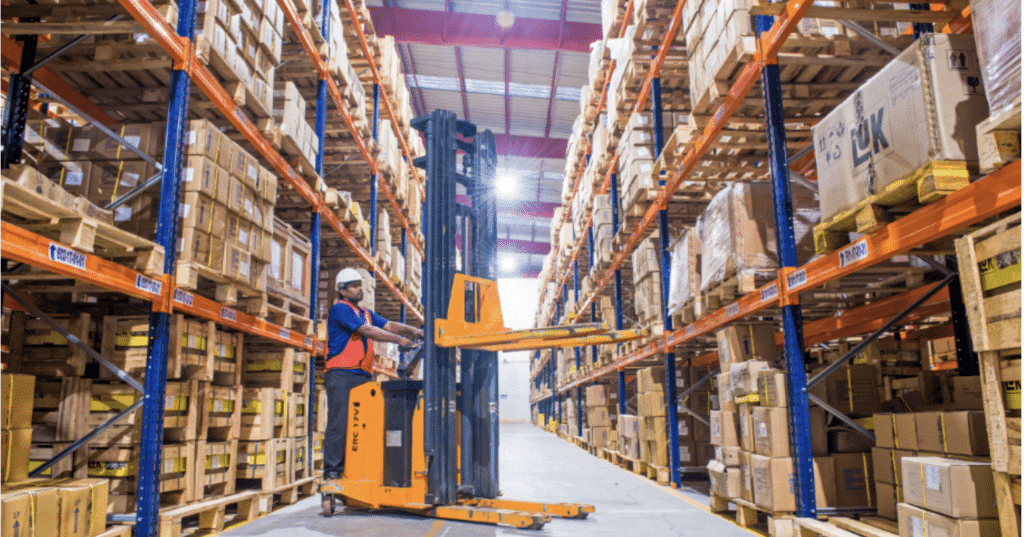 Picture showing a worker handling inventory in a warehouse. 