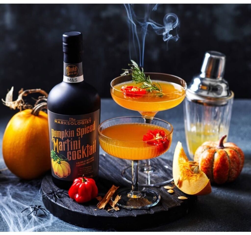an example of a Halloween post idea with a themed orange-colored cocktail