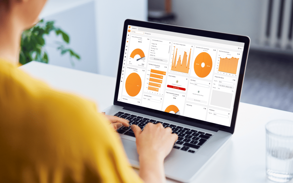 Woman uses KORONA Studio on a laptop to analyze employee hours and reports