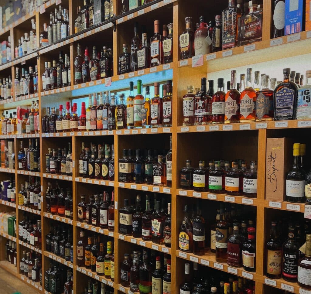 shelves in a liquor store hold an assortment of different brands