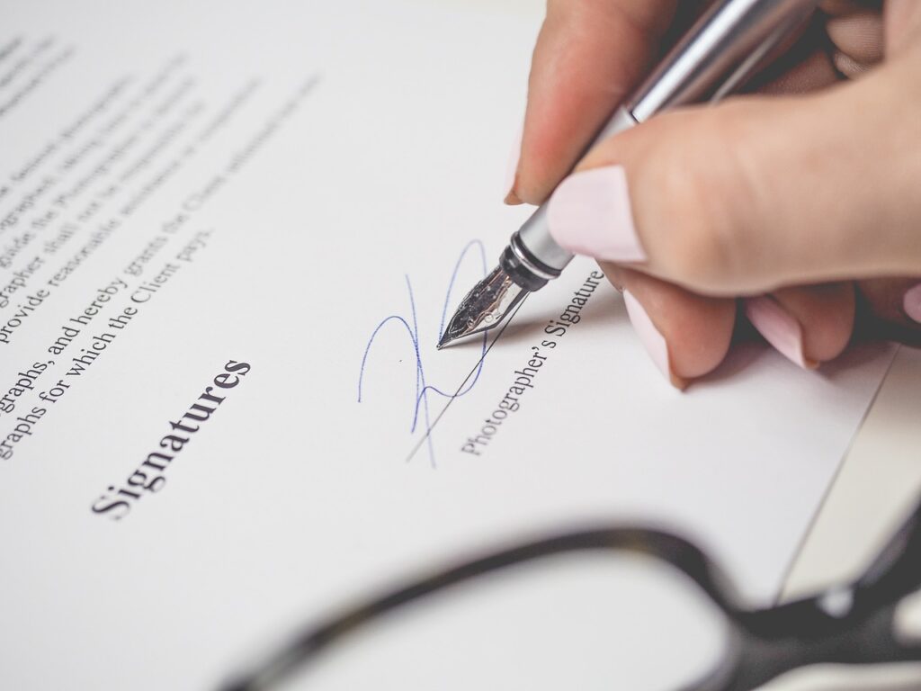 Person makes a signature on a document for a retail business agreement